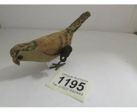 A clock work pecking bird with key.