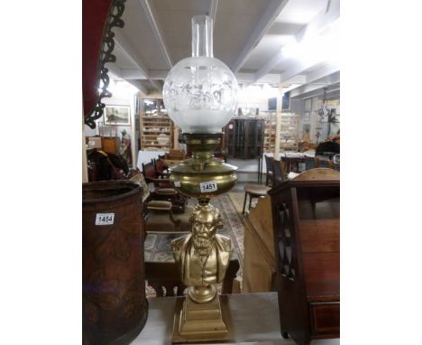 A brass oil lamp with figured stand.