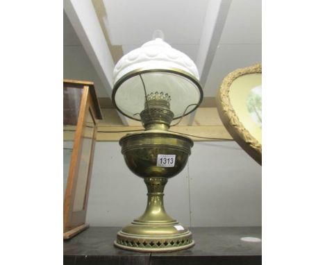 A brass oil lamp with white shade.
