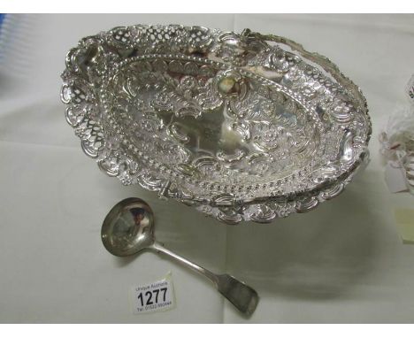An ornate silver plated basket and a ladle.