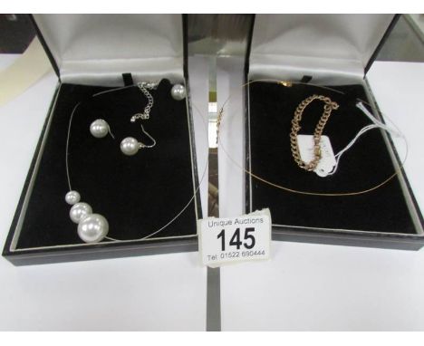 A 9ct gold necklace, a 9ct gold chain and a white metal necklace with matching earrings.