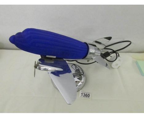 An art deco style chrome airplane table lamp with blue glass shade.