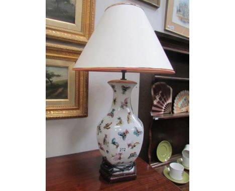 A ceramic table lamp decorated with butterflies.