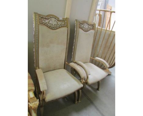 A pair of silver and gold painted ormolu hall chairs with leather upholstery.