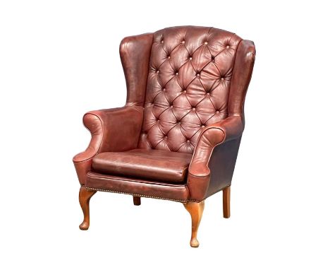 A deep button ox-blood leather wingback armchair on Queen Anne legs. 