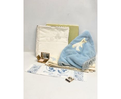 A sundry lot. Including a pair of wooden clogs, a vintage musical compact, linen, vintage throws and a Coronation table mat f