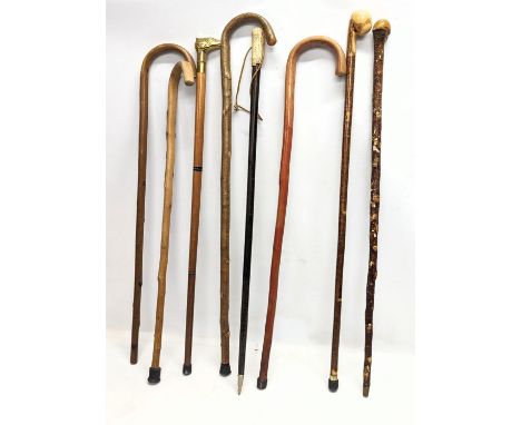 A quantity of vintage walking sticks including an early 20th century bone handled stick. 