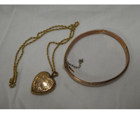 A 9ct gold oval bangle with engraved decoration and a 9ct gold heart-shaped locket pendant with rope-twist chain