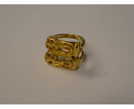 An 18ct gold dress ring with raised and pierced Egyptian figure decoration