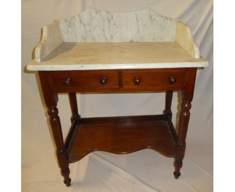 A small Victorian mahogany wash stand with two drawers in the frieze above an open shelf below white marble slab top 30" wide