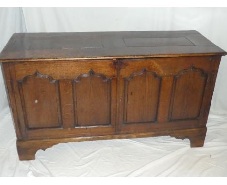 An 18th Century carved oak rectangular coffer, adapted as a two door side cabinet on bracket feet