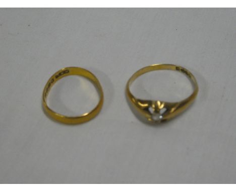 An 18ct gold dress ring set a small diamond and a 22ct gold wedding band