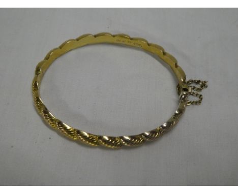 A 9ct gold oval bangle with rope-twist decoration