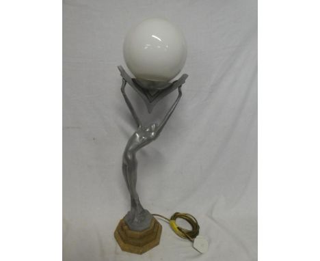 A modern aluminium Art Deco-style table lamp in the form of a scantily clad female holding a sphere aloft on marble stepped b