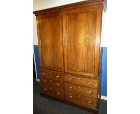 An early 19th Century mahogany linen press, the base with six small drawers with brass ring handles, the upper portion with s