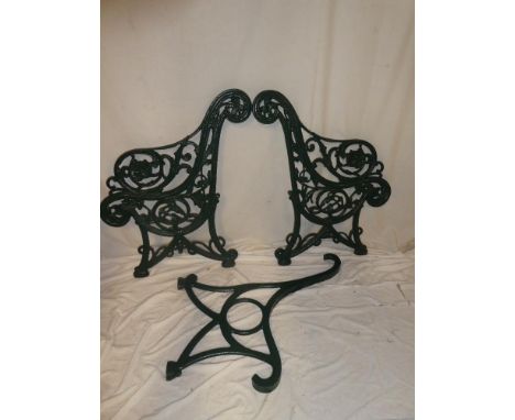 A pair of Victorian cast iron garden bench ends with floral and scroll decoration together with iron central support piece