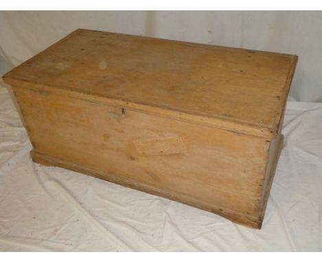 An old polished pine rectangular trunk with hinged lid on bracket feet