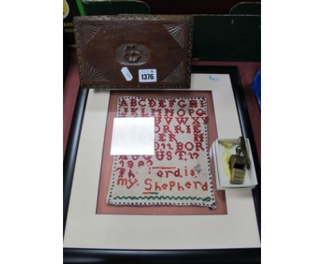 A XIX Century Sampler, with the alphabet, together with a carved wooden box, McPherson Brothers "The Thunderer Patent Whistle