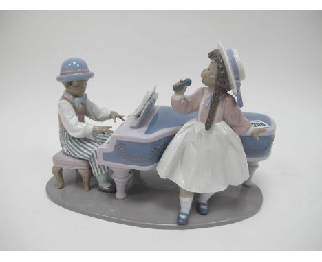 A Lladro Figure Group of Girl Singing by Man Playing Piano, '5930' and K-1E stamped under oval base, 32cm wide.