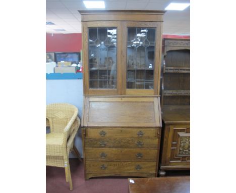 An Early XX Century Oak Bureau Bookcase, with stepped pediment, glazed leaded doors, fall front over four long drawers, on br