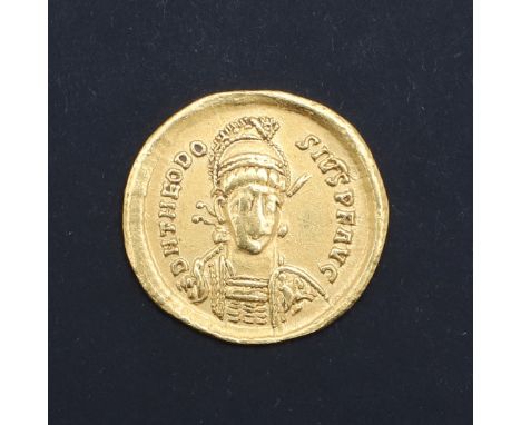 A gold solidus, armoured bust facing slightly to the right, wearing a helmet and holding a spear in his right hand and shield