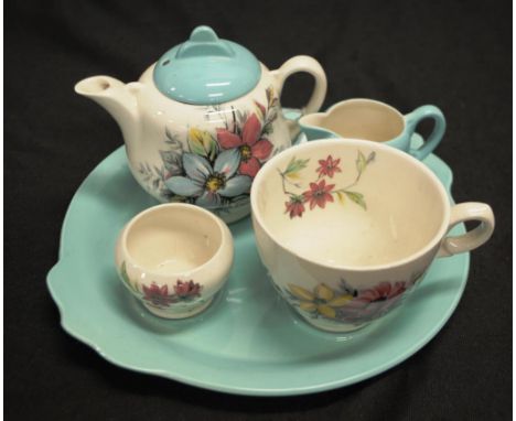 Clarice Cliff ceramic tea for one set comprising: a blossom painted teapot for 1, with matching teacup, and sugar bowl, and m