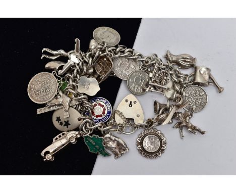 A WHITE METAL CHARM BRACELET, curb link bracelet, links unmarked, fitted with thirty four charms, in forms such as a St. Chri