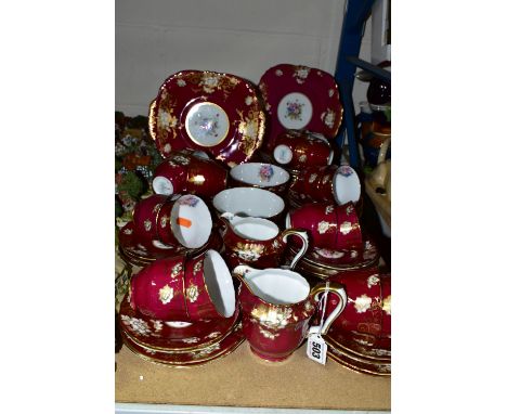 A SIXTY ONE PIECE CROWN STAFFORDSHIRE TEA SET, pattern no A14782, having gilt and white floral decoration on a burgundy groun