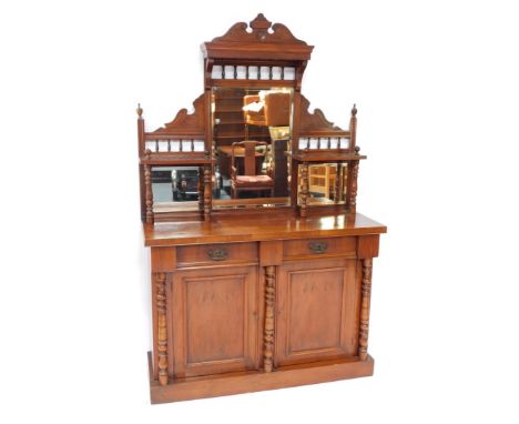 A Victorian walnut chiffonier, or side cabinet, the raised back with three bevelled mirrored plates, on turned supports, the 