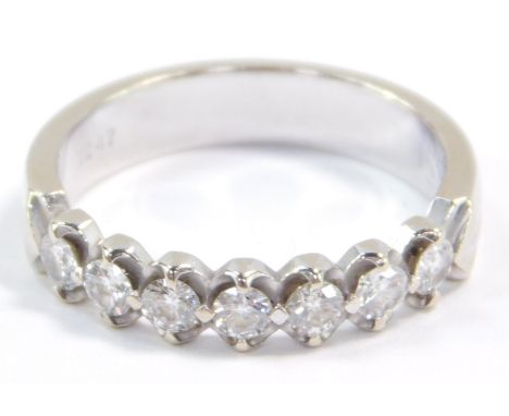 A diamond seven stone half hoop eternity ring, set in white metal, stamped 18k, approximately a 0.25ct, size M, 3.5g.