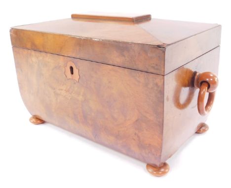 A Victorian figured walnut sarcophagus tea caddy, with loop handles, raised on bun feet, 25cm wide.