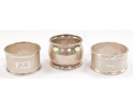 Two silver napkin rings, with engine turned decoration, and rectangular reserves, one monogram engraved, Birmingham 1955 and 