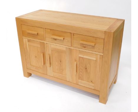 A light oak sideboard, plank top, with three frieze drawers and three paneled doors, on stiles, 87cm high, 120cm wide, 50cm d