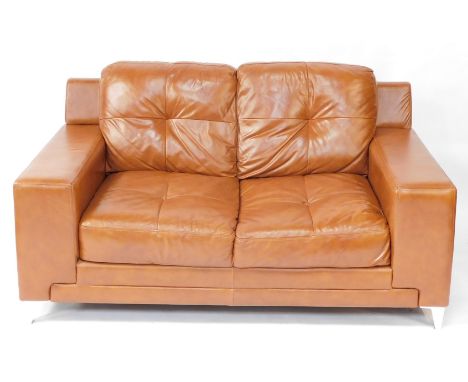 A tan leather two seater sofa, raised on metal bracket feet, 162cm long.