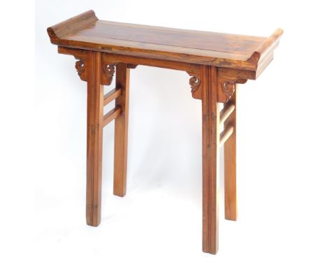 A Chinese or Korean elm small altar table, with plank top and raised sides, on channeled legs with scroll carved brackets, 85