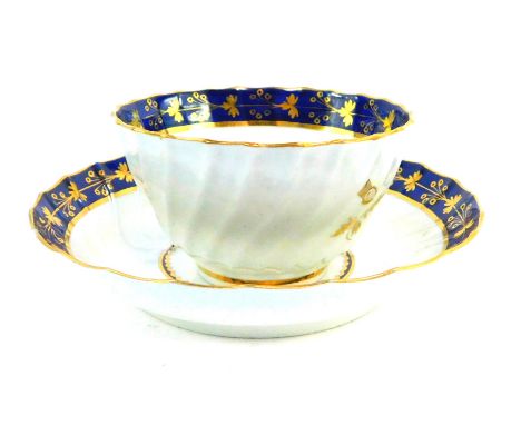 A First Period Worcester  porcelain tea bowl and matching saucer, having blue scale rim with gilt floriate decoration, with a