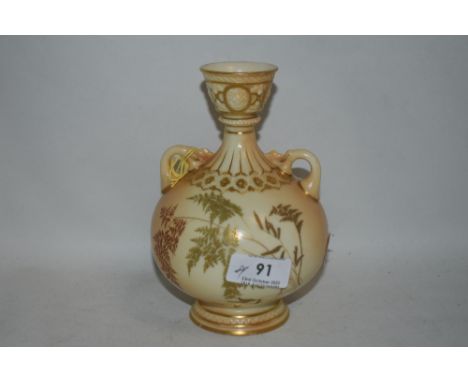 A Royal Worcester blush ivory twin handle vase with Greek style fluted neck and gilt borders with decorated fern design