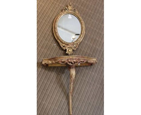 A fancy gilt framed oval plain plate wall mirror, together with a gilded mono-pedic console table, 59cm wide