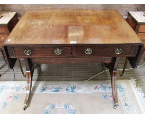 Early 19th century mahogany sofa table of typical form and construction, down swept legs terminating in brass cap casters 72 