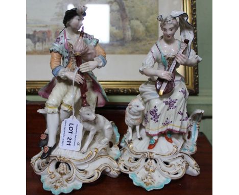 A pair of Derby porcelain figures, a shepherd with his dog &amp; shepherdess with lamb, both playing musical instruments, the