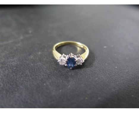 An 18ct yellow gold sapphire and diamond ring, the central sapphire approx 6mm x 4mm x 3mm, ring size K, approx 3 grams - in 