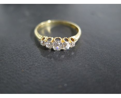 An 18ct gold and diamond ring set with 5 stones - the central stone being approximately 0.25 carats - total carat weight appr