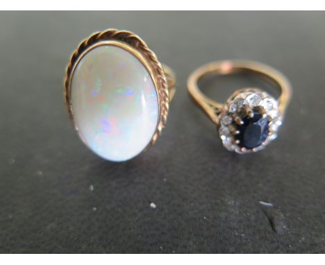 A 9ct yellow gold ring with large oval cut opal to shoulder, size K, approx 7.1 grams and a 9ct yellow gold ring with oval cu