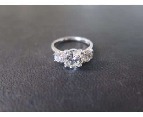 A good platinum and diamond three stone ring size O - The central round brilliant cut diamond, approx 2.12ct, colour K, clari