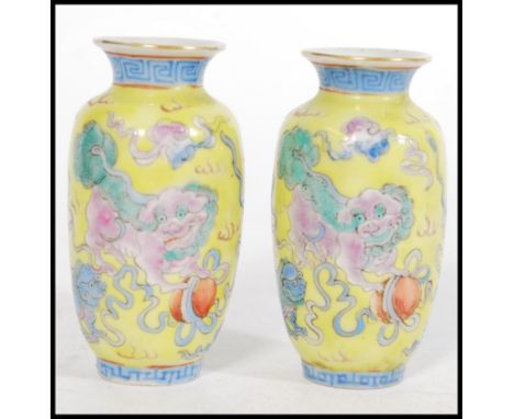 A pair of 19th century Canton Enamel Chinese miniature vases having a famille Juan ground with depictions of Fu Dog Temple Li