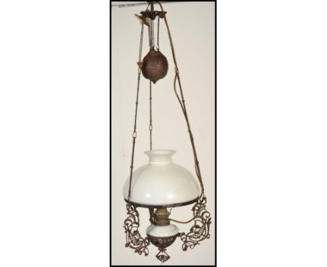 A late 19th Century brass rise and fall ceiling oil light with milk glass shade having a later conversion to electric.
