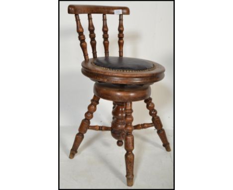 A 19th century mahogany artist revolving stool with turned spindle back having a studded seat.