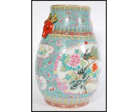 A 20th century Chinese large ceramic vase of bulbous form having ocher red stag handles with gilded antlers. Hand enamelled d