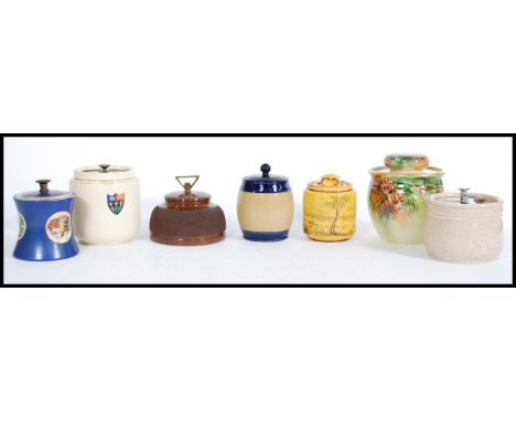 A selection of vintage tobacco jars to include a hand painted jar with painted pine cones, a Royal Doulton tobacco jar with a
