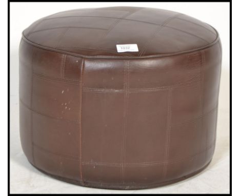 A vintage retro 20th century brown vinyl pouffe of circular form.